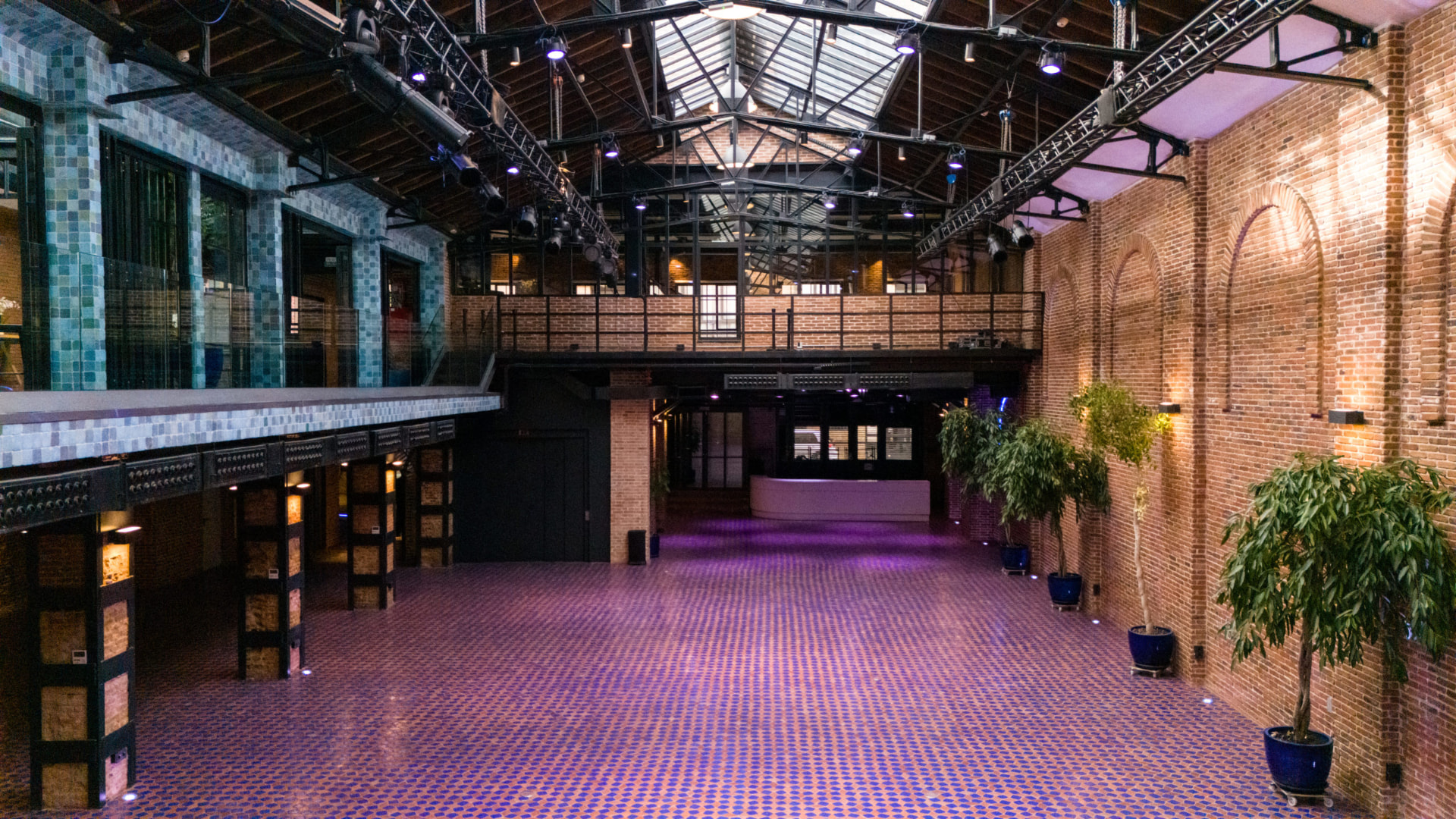 Wide view of La Imprenta's hall with greenery and stage lighting